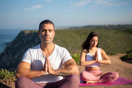 Man and woman meditating in nature.