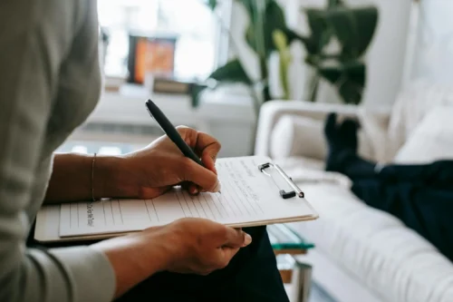 therapist writing on clipboard