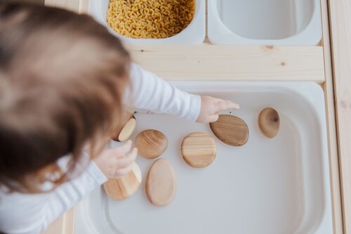 Photo by Tatiana Syrikova: https://www.pexels.com/photo/crop-anonymous-child-getting-brown-stones-from-white-container-at-home-3933101/