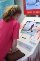 Young girl learning Hands-Only CPR at the American Heart Association Hands-Only CPR training kiosk at Cincinnati-Northern Kentucky International Airport. copyright American Heart Association 2017 Photos by Tommy Campbell Photography