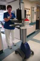 "Portable Information station, nurse, computer, hand wipes, 9th floor, Virginia Mason Hospital, Seattle, Washington, USA" by Wonderlane is licensed under CC BY 2.0